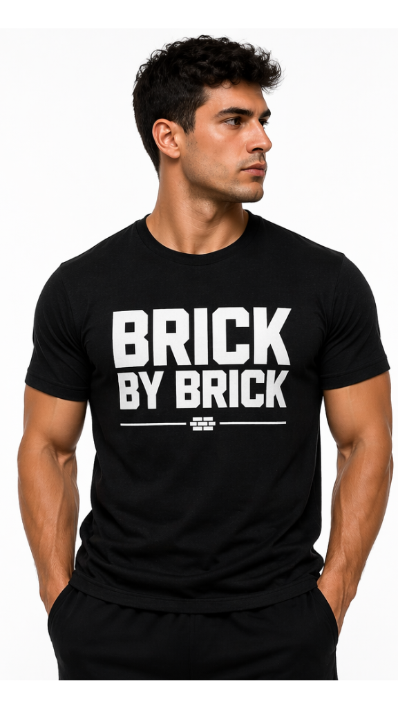 Man wearing a black t-shirt with 'BRICK BY BRICK' text on a white background